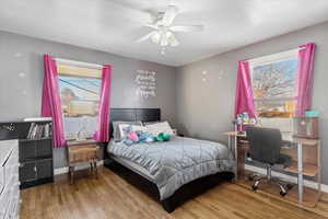 Bedroom with light hardwood / wood-style floors and ceiling fan