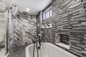 Bathroom featuring separate shower and tub and a textured ceiling