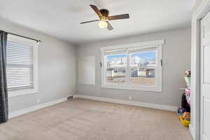 Unfurnished bedroom featuring ceiling fan and light carpet