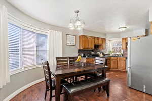 Dining space featuring a wealth of natural light, dark hardwood / wood-style floors, and a notable chandelier