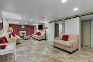 Family room downstairs featuring a barn door and a brick fireplace