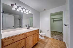 Bathroom with tile patterned floors, a shower, vanity, and toilet