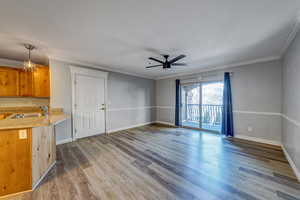 Interior space featuring ceiling fan, ornamental molding, sink, and light hardwood / wood-style flooring