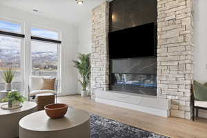 Living room featuring hard wood flooring, stone surround fireplace.