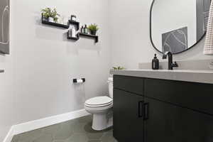 Bathroom with tile patterned floors, vanity, quartz counter tops