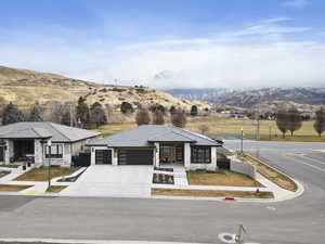 View of front of property with a mountain view, a porch, and a garage