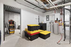 Basement with electric panel, theatre room components and tankless water heater, water softner.