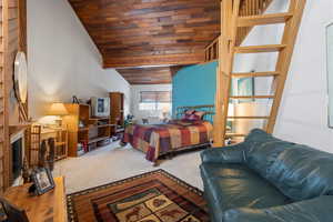 Carpeted bedroom featuring wooden ceiling and vaulted ceiling