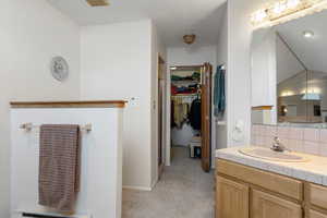 Bathroom featuring vanity and tasteful backsplash