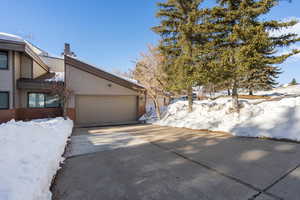 Snow covered property with a garage