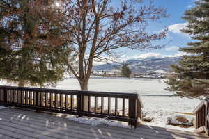 Snow covered deck with a mountain view