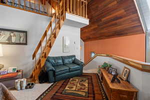 Living room featuring carpet flooring, high vaulted ceiling, and wooden ceiling