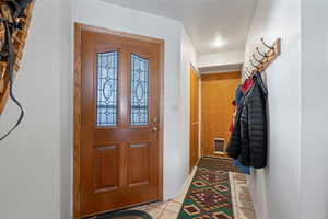 Tiled foyer with a textured ceiling