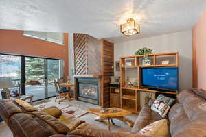 Carpeted living room with a tile fireplace and a textured ceiling