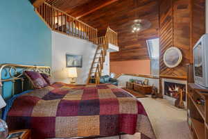 Carpeted bedroom with high vaulted ceiling and wooden ceiling