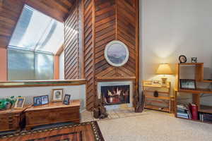 Sitting room with light carpet and high vaulted ceiling