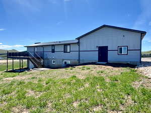 Back of house featuring a wooden deck and stairs