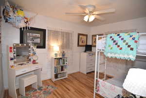 Bedroom #2 featuring light hardwood flooring and ceiling fan