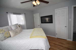 Main Bedroom featuring ceiling fan, hardwood floors and dual closets