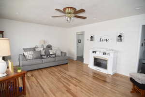 Living room featuring ceiling fan and light hardwood flooring