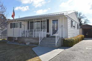 View of front of house featuring a front lawn and covered porch