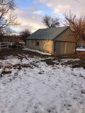 View of snowy exterior with an outdoor structure