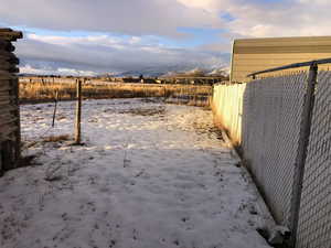 Yard layered in snow with a mountain view