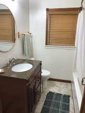 Full bathroom with vanity, toilet, and shower / bathtub combination with curtain