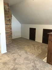 Bonus room with carpet, lofted ceiling, and a textured ceiling