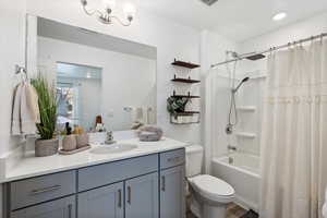 Full bathroom with shower / tub combo, vanity, hardwood / wood-style flooring, and toilet