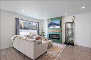 Living room with hardwood / wood-style floors, a large fireplace, and a textured ceiling