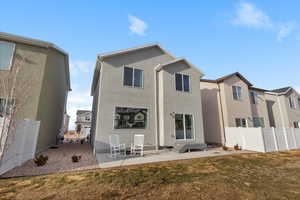 Rear view of property with a lawn and a patio