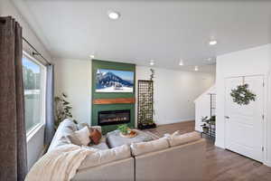 Living room with a large fireplace and dark wood-type flooring