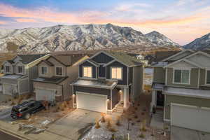 View of front of home with a mountain view and a garage