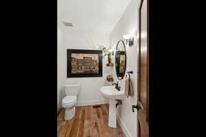 Bathroom featuring hardwood / wood-style flooring, toilet, and sink