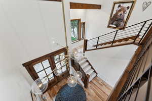 Staircase with hardwood / wood-style floors, an inviting chandelier, and french doors