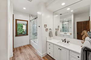 Bathroom with shower / bath combination with glass door, wood-type flooring, and vanity