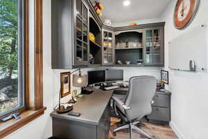 Office featuring built in desk and wood-type flooring