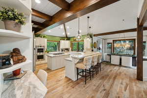 Kitchen featuring a kitchen island, a breakfast bar area, hanging light fixtures, and stainless steel appliances