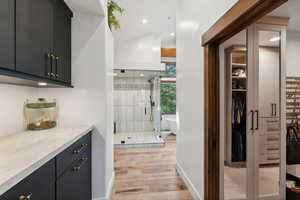 Bathroom with vanity, shower with separate bathtub, and hardwood / wood-style flooring