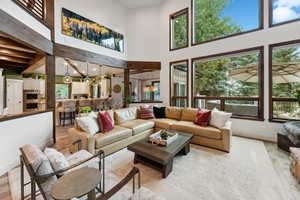 Living room with a high ceiling and light hardwood / wood-style flooring