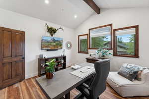 Home office featuring lofted ceiling with beams and light hardwood / wood-style flooring