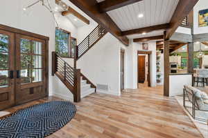 Entryway featuring wooden ceiling, french doors, lofted ceiling with beams, and light hardwood / wood-style floors