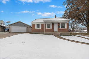 View of front of home with a garage and an outdoor structure