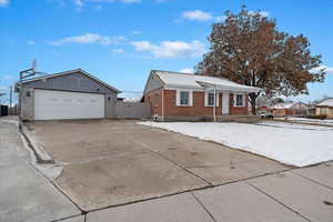 View of front of house featuring a garage and an outbuilding