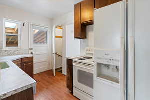 Kitchen featuring light wood-type flooring and white appliances