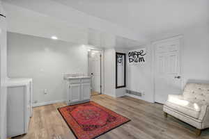 Sitting room featuring light wood-type flooring, sink, and separate washer and dryer