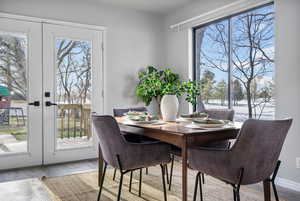 Dining area with light hardwood / wood-style floors and french doors