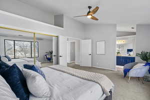 Carpeted bedroom featuring ceiling fan, high vaulted ceiling, and a closet