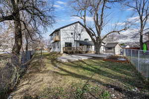 Back of house featuring a deck with mountain view and a lawn